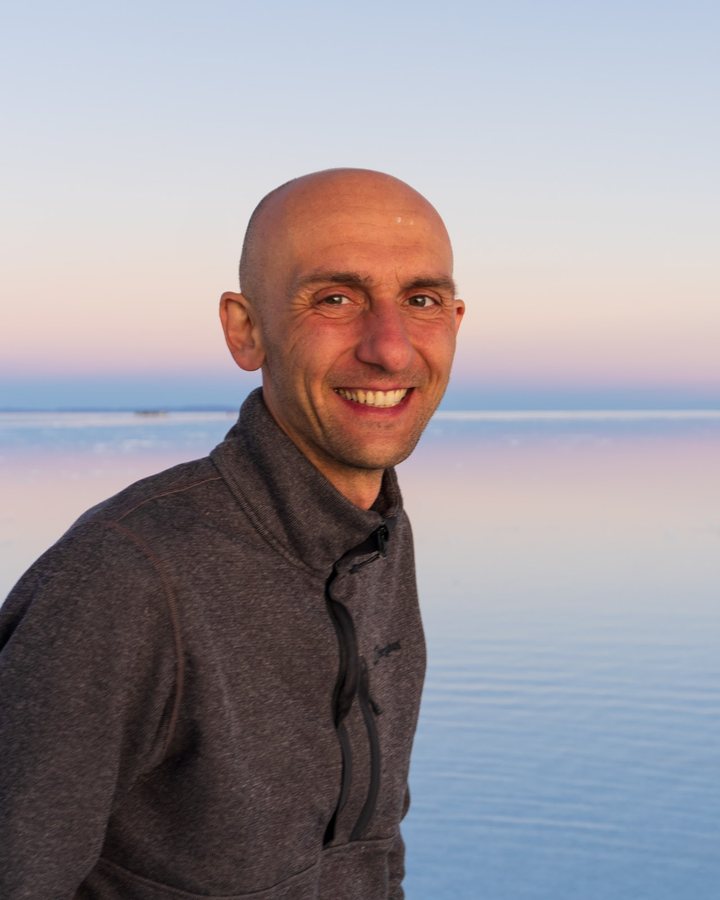 Alex smiling at sunset on the salt flats in Bolivia